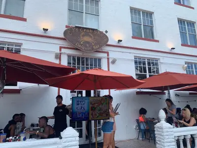 a group of people sitting at a restaurant under umbrellas at Luxury white loft on Ocean Drive-South beach with a view in Miami Beach