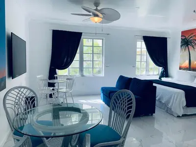 a living room with a glass table and chairs at Luxury white loft on Ocean Drive-South beach with a view in Miami Beach