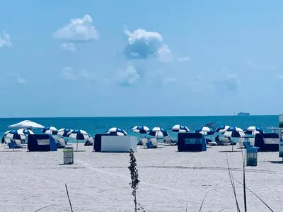 a beach with umbrellas and chairs on the sand at Luxury white loft on Ocean Drive-South beach with a view in Miami Beach