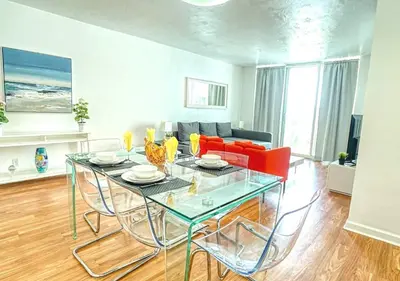 a living room with a glass table and a couch at Hallandale Beach Intracoastal View Apartments in Hollywood
