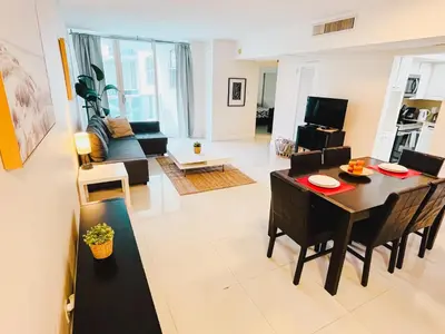 a living room with a table and a dining room at Hallandale Beach Intracoastal View Apartments in Hollywood