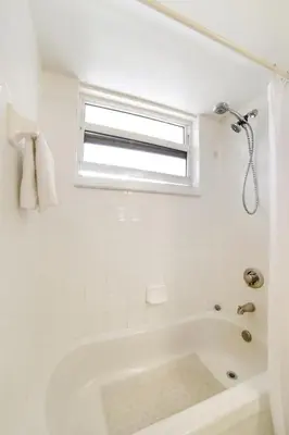 a white bathroom with a tub and a window at Miami Downtown City view 3BR Air Hockey &Ping Pong table in Miami