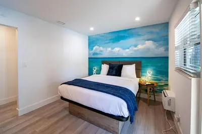 a bedroom with a painting of the ocean at The Lauderdale Boutique Hotel in Fort Lauderdale