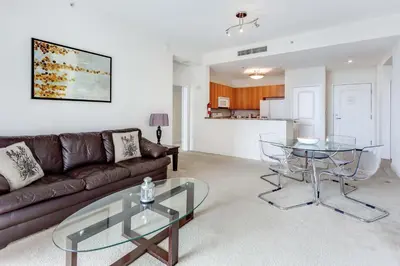 a living room with a couch and a glass table at Dadeland Towers by Miami Vacations in South Miami