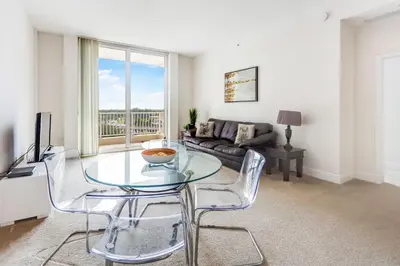a living room with a glass table and a couch at Dadeland Towers by Miami Vacations in South Miami