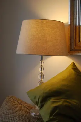 a lamp sitting next to a bed with a green pillow at Dadeland Towers by Miami Vacations in South Miami