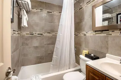 a bathroom with a shower curtain and a toilet and a sink at Downtown Hollywood Gardens Inn & Suites in Hollywood