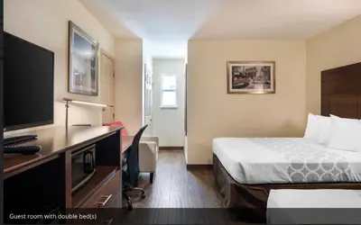 a hotel room with a bed and a flat screen tv at Downtown Hollywood Gardens Inn & Suites in Hollywood