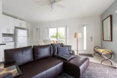 a living room with a brown leather couch at Spectacular view on the canal, Fort Lauderdale, very clean, free Parking & Wifi in Fort Lauderdale