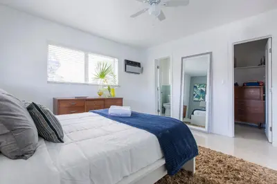 a white bedroom with a bed and a mirror at Spectacular view on the canal, Fort Lauderdale, very clean, free Parking & Wifi in Fort Lauderdale