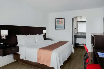 a hotel room with a large bed and a bathroom at Quality Inn Miami South in Kendall