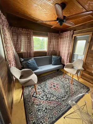a living room with a couch and two chairs and a rug at Updated houseboat on the river! in Fort Lauderdale