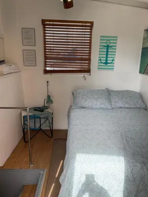 a small bedroom with a bed and a window at Updated houseboat on the river! in Fort Lauderdale