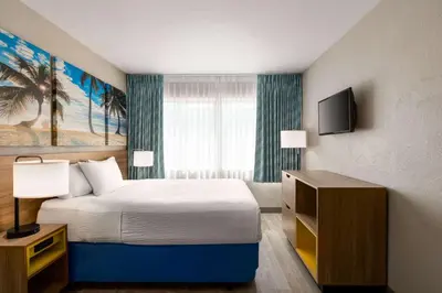 a hotel room with a bed and a television at Days Inn by Wyndham Miami Airport North in Miami