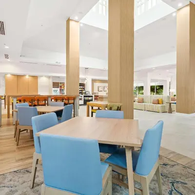 a dining room with a table and blue chairs at Hilton Garden Inn Ft. Lauderdale Airport-Cruise Port in Dania Beach