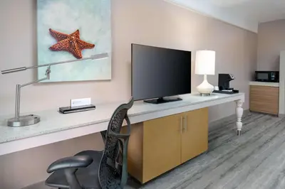 a room with a desk with a television and a chair at Hilton Garden Inn Ft. Lauderdale SW/Miramar in Miramar