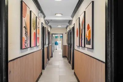 a hallway with many paintings on the walls at Baybreeze Apartments by Lowkl in Miami Beach