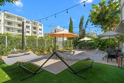two hammocks and an umbrella in a yard at Baybreeze Apartments by Lowkl in Miami Beach