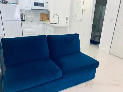 a blue couch in a living room with a kitchen at Beach House BEACHFRONT STUDIO 107 in Miami Beach