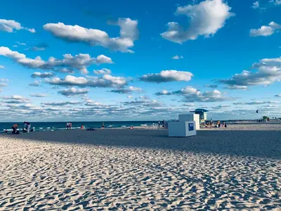 a beach with people on the sand and the ocean at Beach House BEACHFRONT STUDIO 107 in Miami Beach