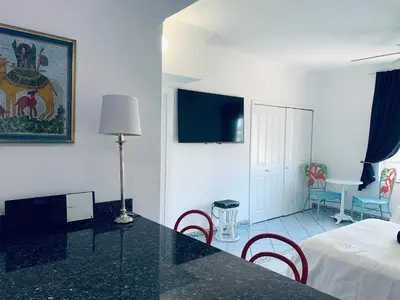 a room with a table and chairs and a bed at Beachfront Ocean Dr white sand paradise SoBe 311 in Miami Beach