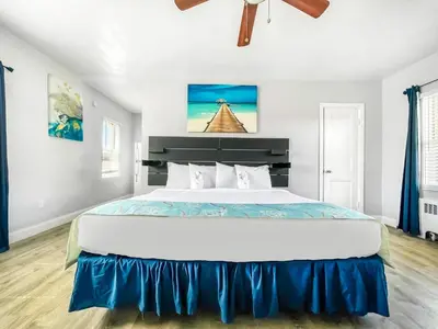 a bedroom with a large white bed with blue sheets at The Palms in Hollywood