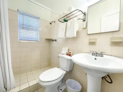 a bathroom with a white toilet and a sink at The Palms in Hollywood