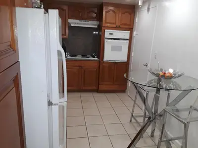 a kitchen with a white refrigerator and a glass table at Tides Apt on Hollywood Beach in Hollywood