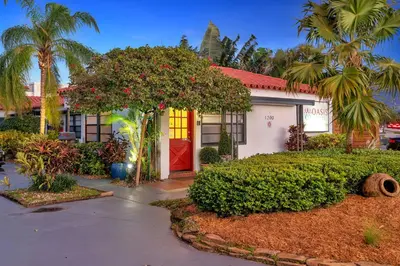 a house with a red door and a tree at Oasis Hotel in Fort Lauderdale