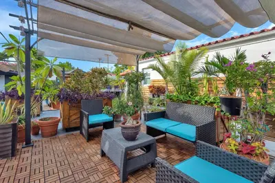 a patio with chairs and potted plants on it at Oasis Hotel in Fort Lauderdale