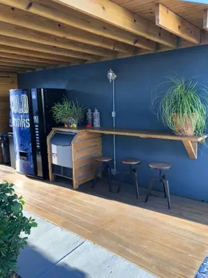 a bar with two stools and a counter with plants at Oasis Hotel in Fort Lauderdale