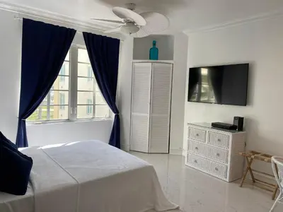 a bedroom with a bed and a tv and a window at SOBE OCEAN VIEW OCEAN DR charming studio -316 in Miami Beach