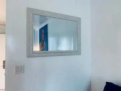a mirror on a white wall with a woman in it at SOBE OCEAN VIEW OCEAN DR charming studio -316 in Miami Beach