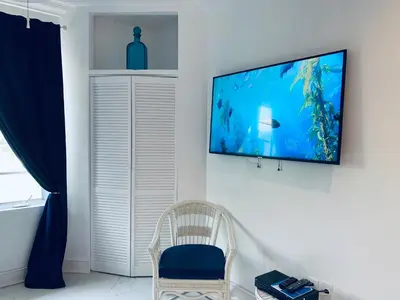 a living room with a television on a wall at SOBE OCEAN VIEW OCEAN DR charming studio -316 in Miami Beach