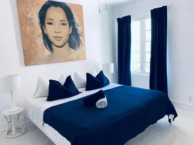 a bedroom with a blue bed with a painting on the wall at vacation home-ocean view SoBe 318 in Miami Beach