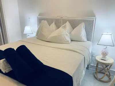 a large white bed with white pillows and two lamps at Beach house -magic SoBe 209 in Miami Beach
