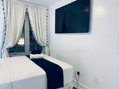 a bedroom with a bed and a television on the wall at Beach house -magic SoBe 209 in Miami Beach