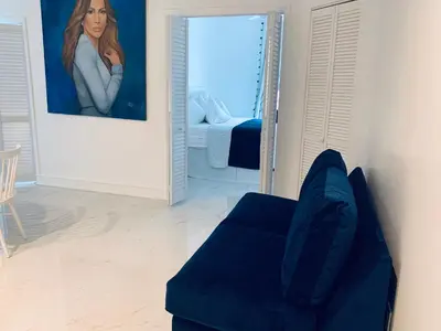 a living room with a blue couch and a mirror at Beach house -magic SoBe 209 in Miami Beach