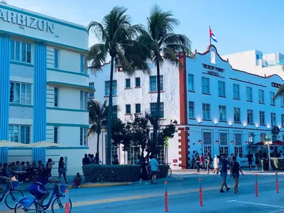 a group of people walking around a street in front of buildings at Beach house -magic SoBe 209 in Miami Beach