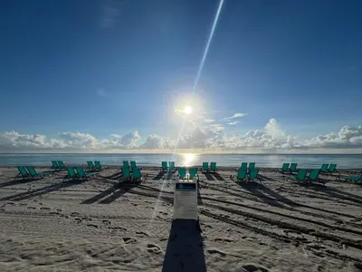a group of chairs on a beach with the sun at Miami Hollywood Great 2BD Condo 009-21mar in Hollywood
