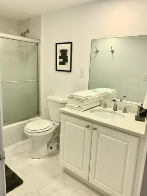 a bathroom with a toilet and a sink and a mirror at Miami Sunny Isles ocean reserve 704 in Miami