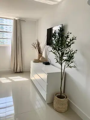 a living room with a tv and a potted plant at Miami Sunny Isles ocean reserve 704 in Miami