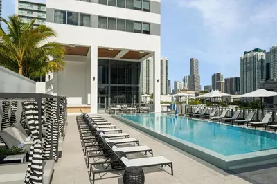 a pool on the rooftop of a building with lounge chairs at AC Hotel By Marriott Miami Brickell in Miami