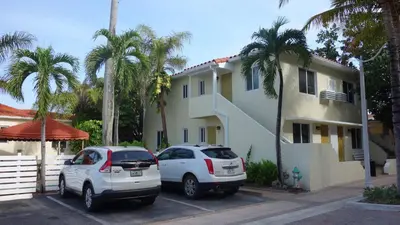 two cars parked in a parking lot in front of a house at Ocean Drive Villas in Hollywood