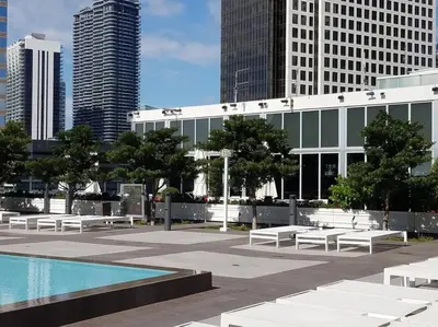 a pool and benches in a city with tall buildings at Iconbrickell in Miami