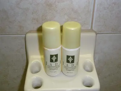 two bottles of moisturizers sitting on top of a urinal at Miami Princess Hotel in Miami