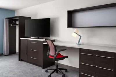 a room with a desk with a monitor and a chair at Home2 Suites by Hilton Miramar Ft. Lauderdale in Miramar
