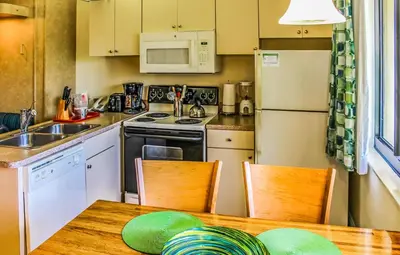 a kitchen with a table and a sink and a refrigerator at Hollywood Sands Resort in Hollywood