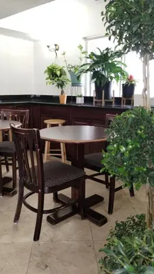 a wooden table with a chair and a table with plants at Super 8 Motel by Wyndham near Fort Lauderdale Arpt in Dania Beach