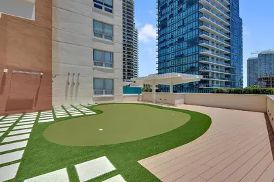 a building with a green lawn in front of a building at Miami Midtown Luxury Apartment in Miami
